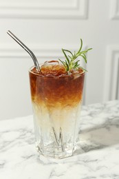 Photo of Refreshing espresso tonic drink with rosemary on white marble table