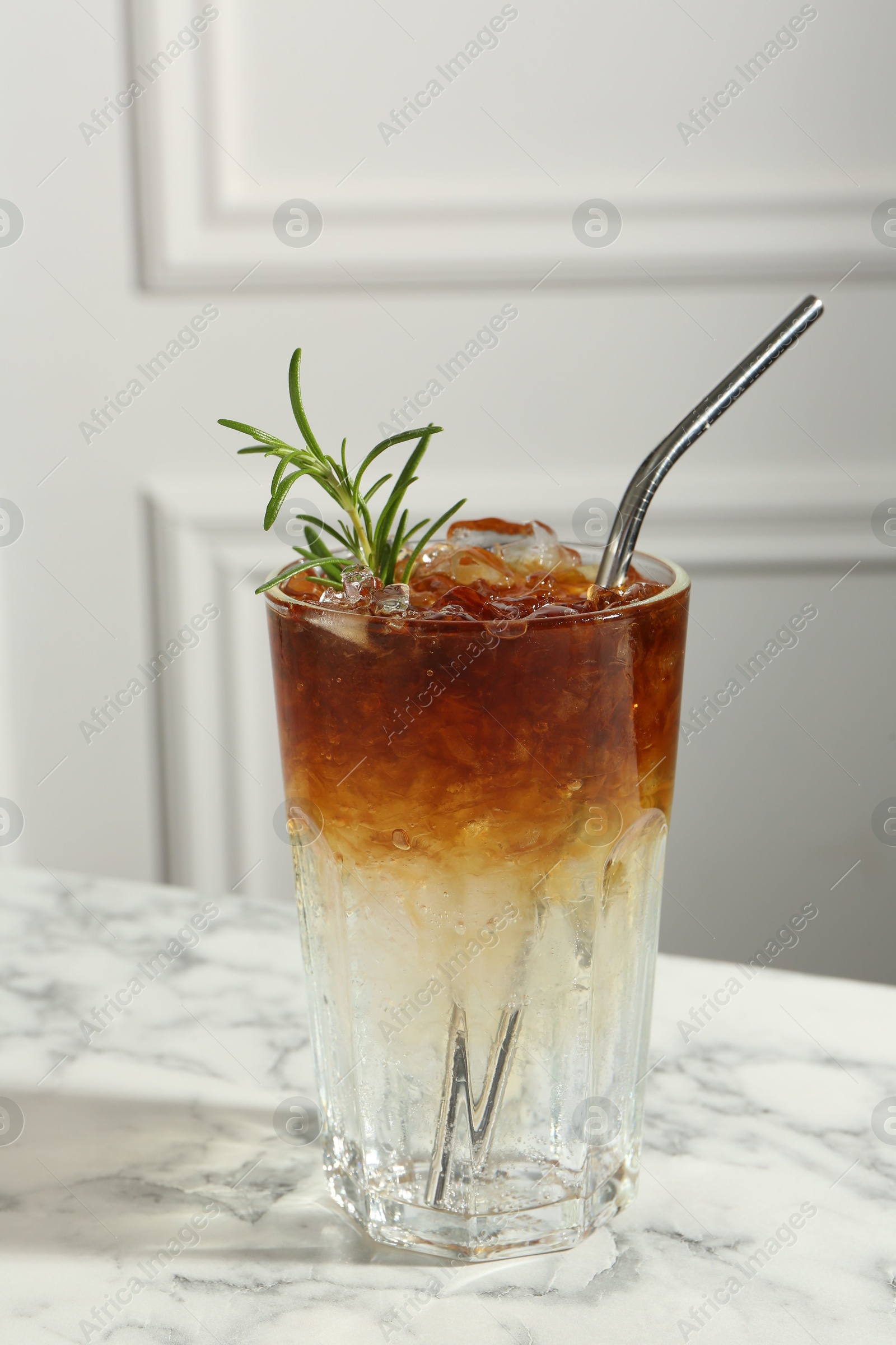 Photo of Refreshing espresso tonic drink with rosemary on white marble table