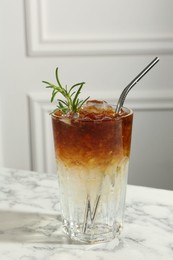 Photo of Refreshing espresso tonic drink with rosemary on white marble table