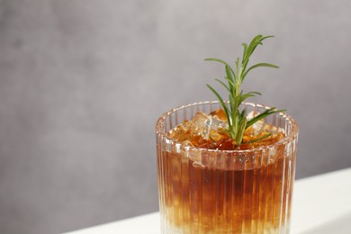 Refreshing espresso tonic drink with rosemary on table, closeup. Space for text