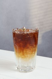 Photo of Refreshing espresso tonic drink on white wooden table