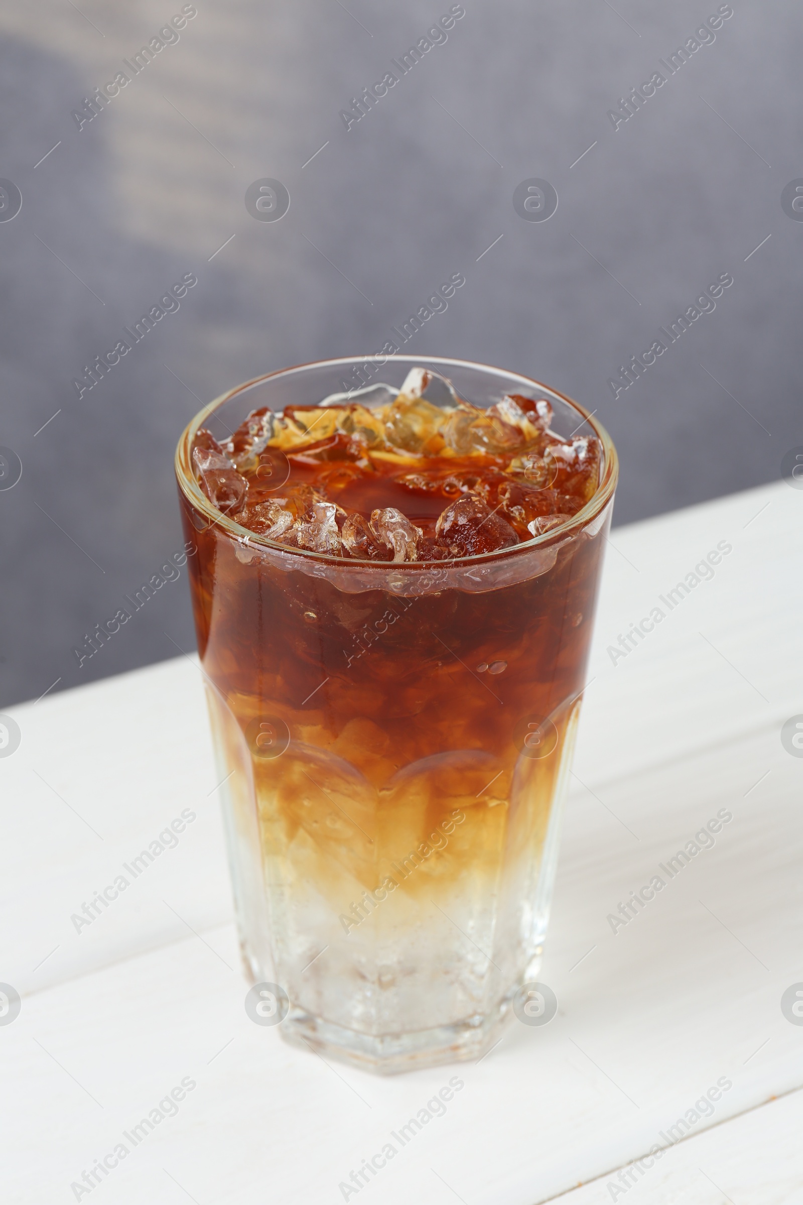 Photo of Refreshing espresso tonic drink on white wooden table