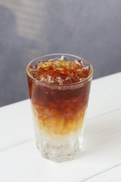 Photo of Refreshing espresso tonic drink on white wooden table