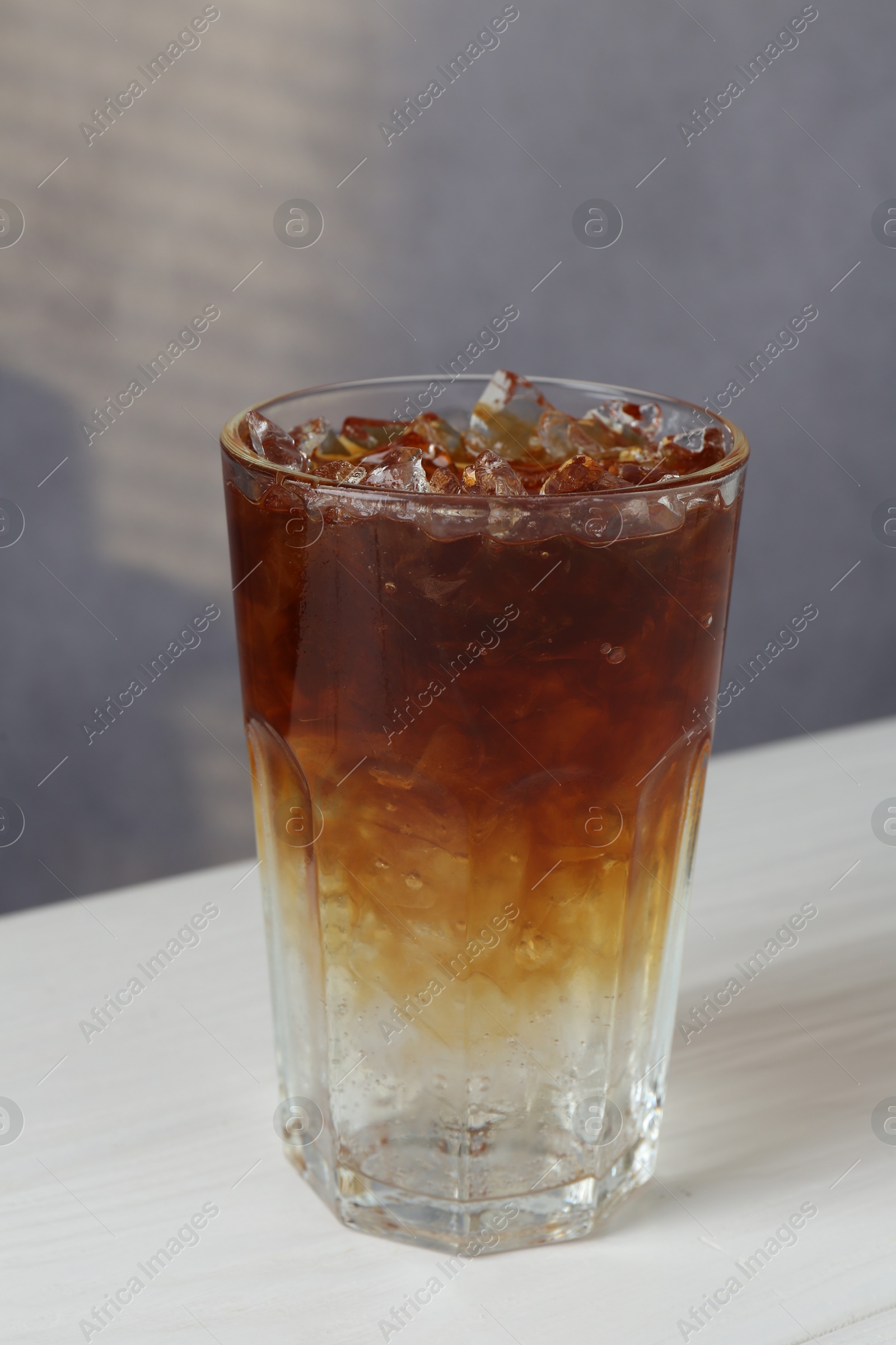 Photo of Refreshing espresso tonic drink on white wooden table