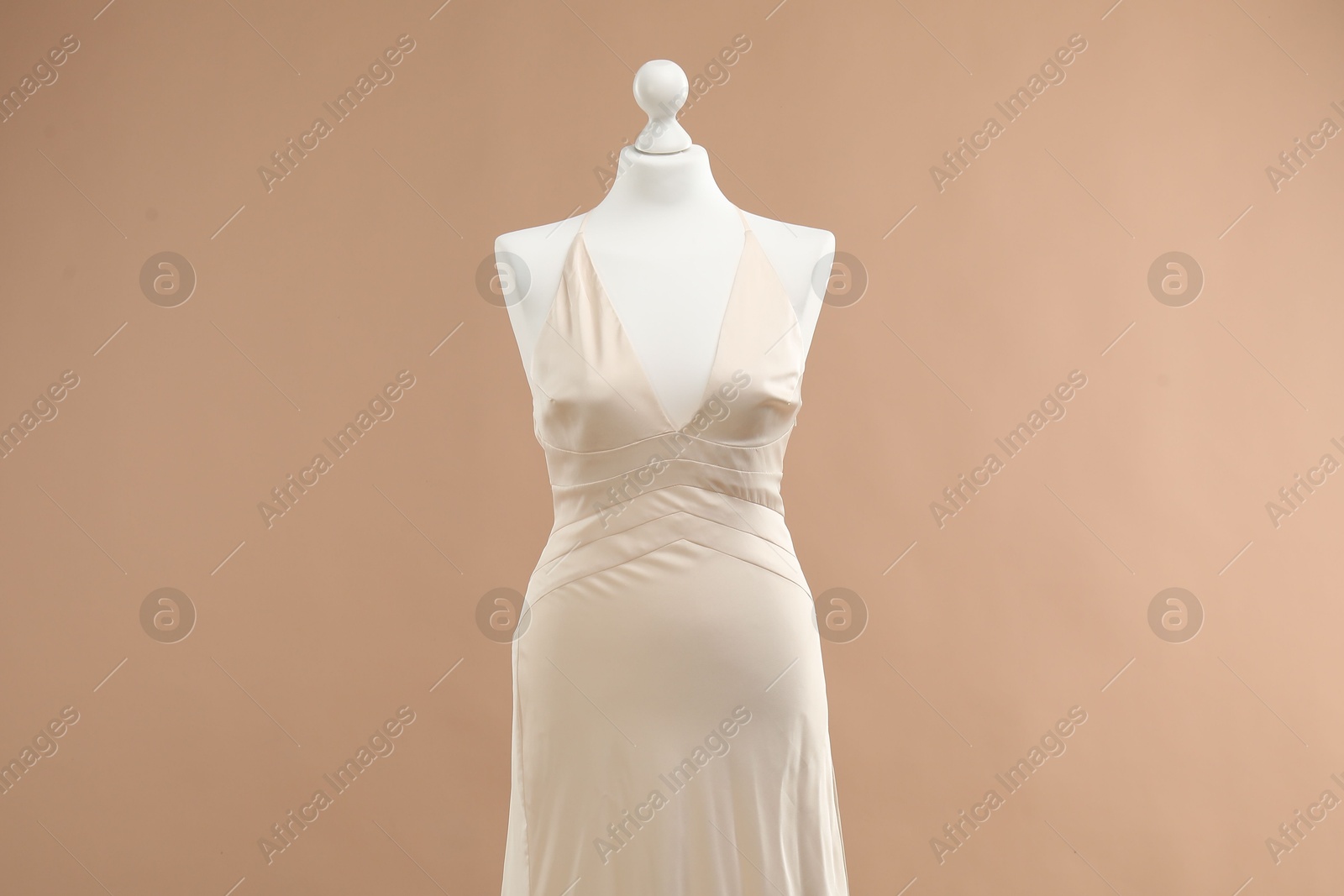 Photo of Mannequin with beautiful wedding dress on pale brown background