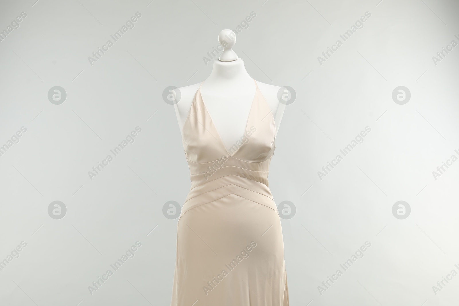 Photo of Mannequin with beautiful wedding dress on light grey background