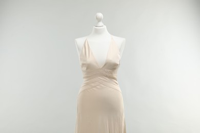 Photo of Mannequin with beautiful wedding dress on light grey background