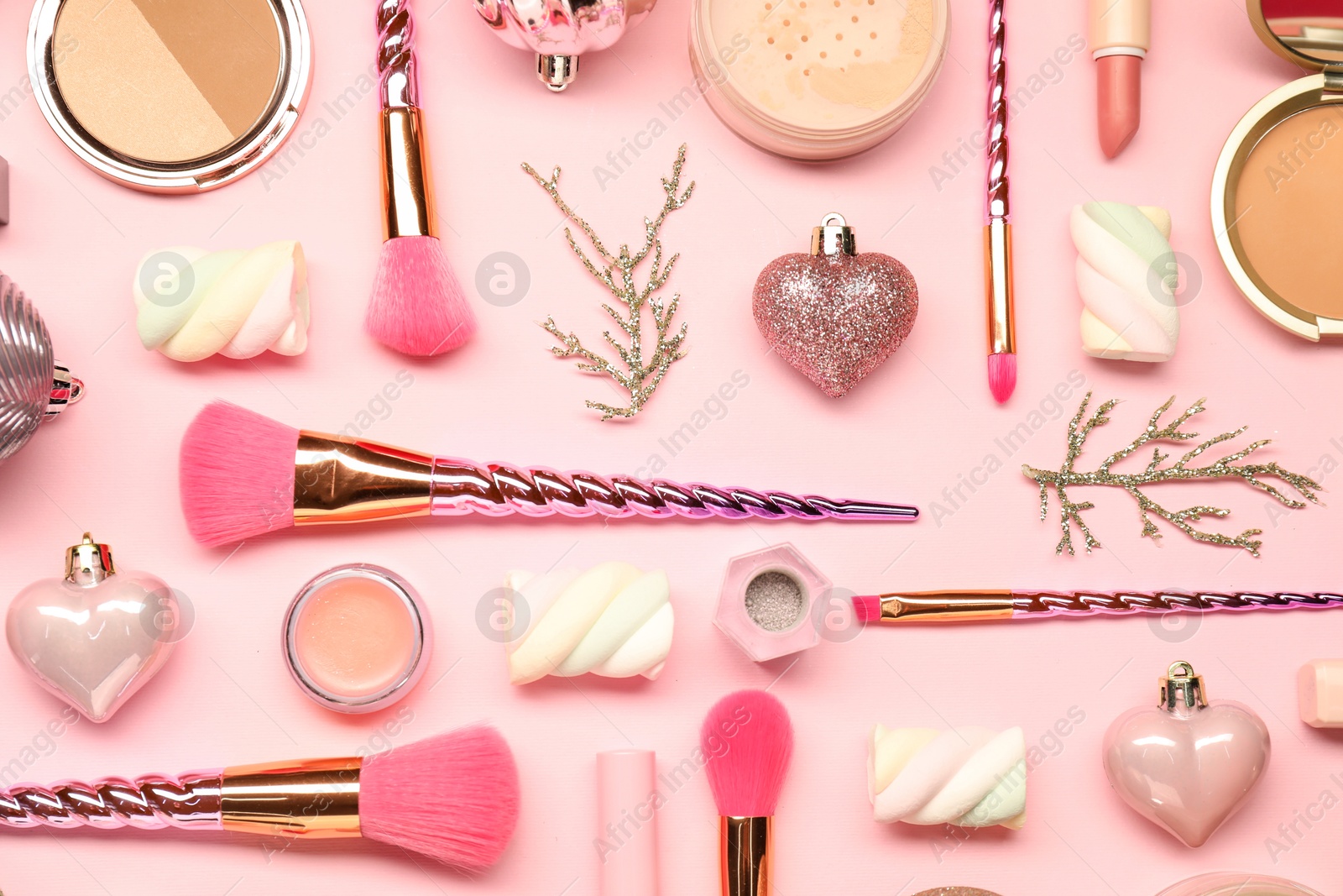 Photo of Different makeup brushes, decorative cosmetics and Christmas decor on pink background, flat lay