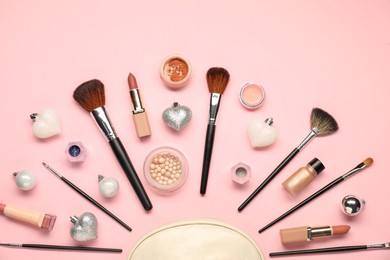 Photo of Cosmetic bag, makeup brushes, decorative cosmetics and Christmas decor on pink background, flat lay