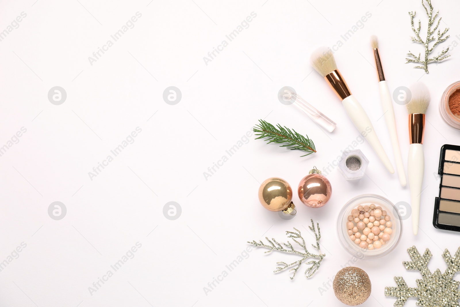 Photo of Different makeup brushes, decorative cosmetics and Christmas decor on white background, flat lay. Space for text