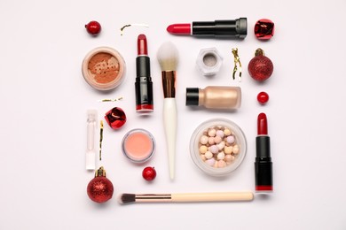 Photo of Different makeup brushes, decorative cosmetics and Christmas decor on white background, flat lay