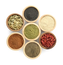 Photo of Different superfood powders, pumpkin seeds and goji berries in bowls isolated on white, top view