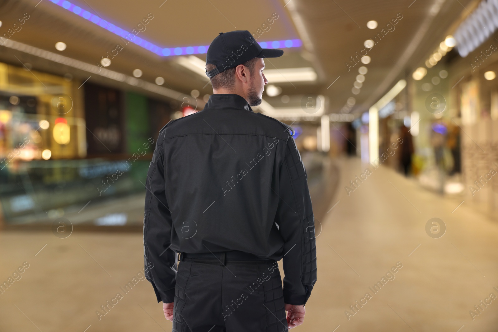 Image of Security guard wearing uniform in shopping mall, back view