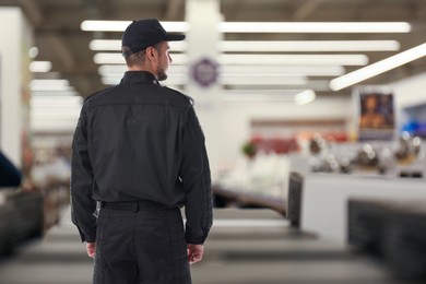 Security guard in supermarket, back view. Space for text