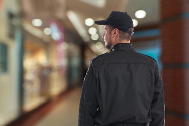 Image of Security guard in shopping mall, back view. Space for text