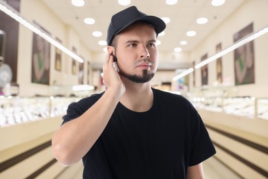 Confident security guard with earpiece in jewelry store