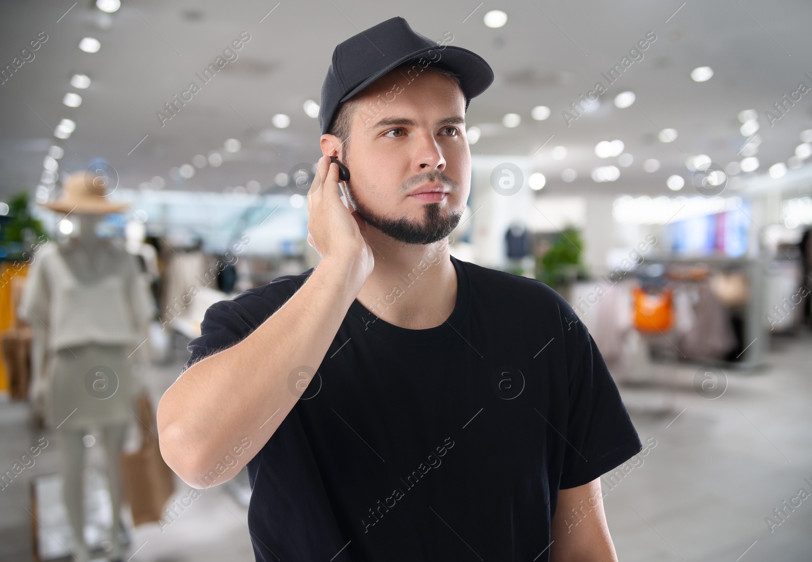 Image of Confident security guard with earpiece in clothing store