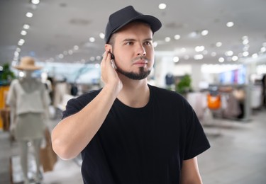 Image of Confident security guard with earpiece in clothing store