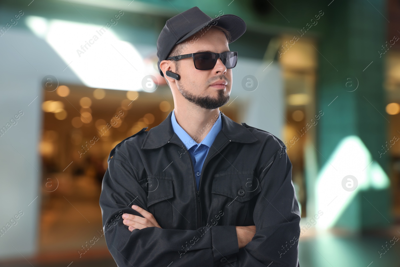 Image of Confident security guard with earpiece in shopping mall