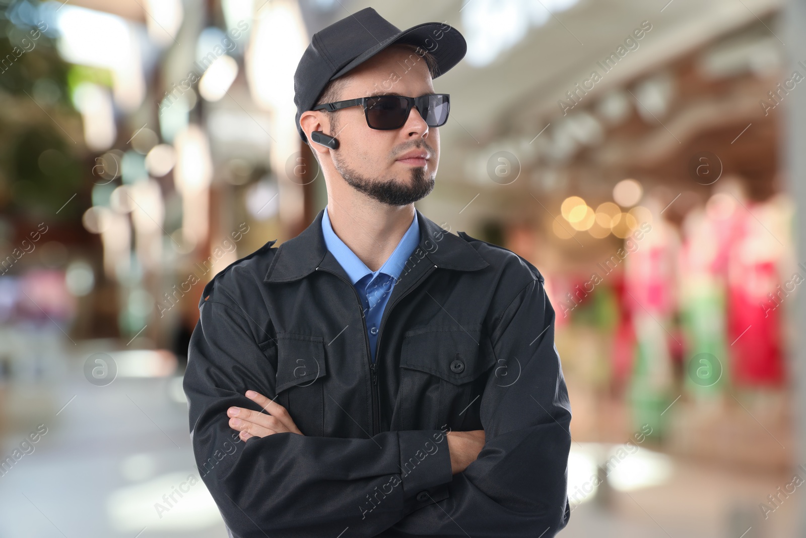 Image of Confident security guard with earpiece in clothing store