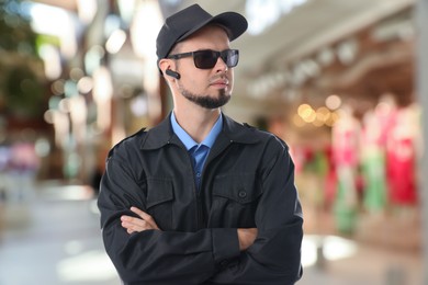 Image of Confident security guard with earpiece in clothing store