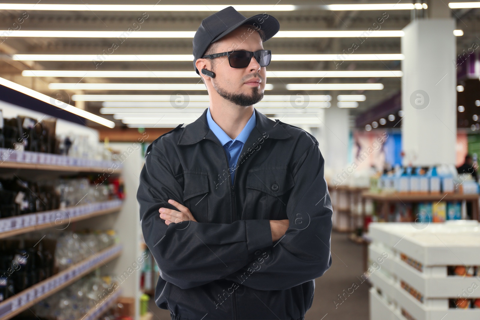 Image of Confident security guard with earpiece in supermarket