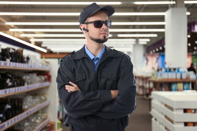 Image of Confident security guard with earpiece in supermarket