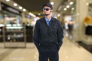 Confident security guard with earpiece in supermarket