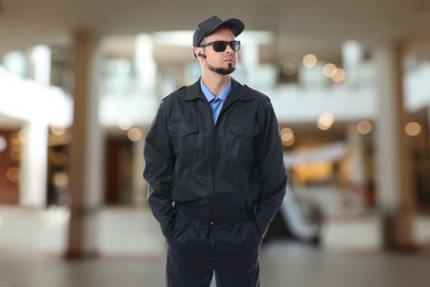 Image of Serious security guard with earpiece in shopping mall