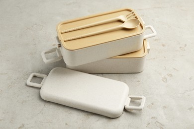 Compartments of plastic lunch box with cutlery on grey table