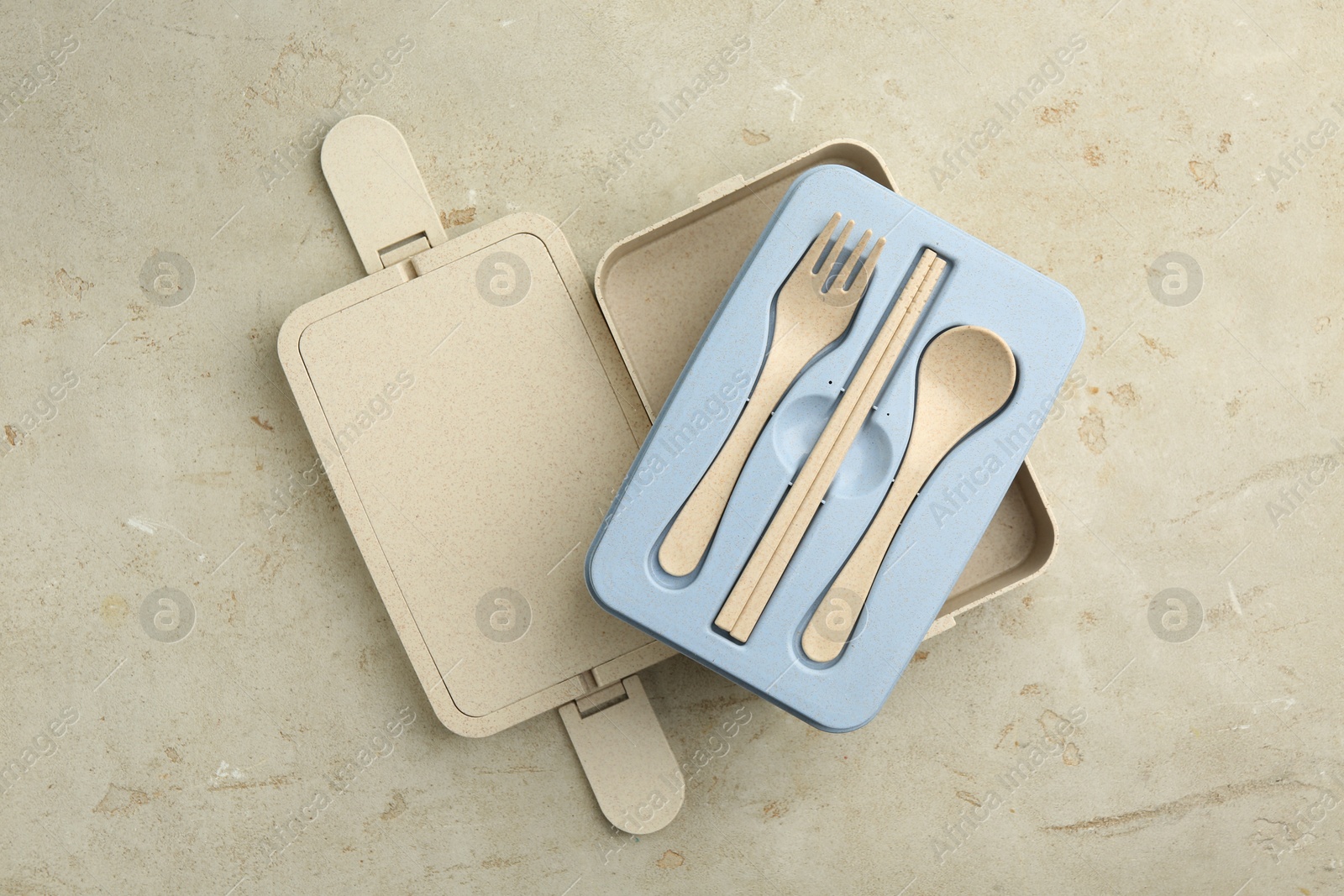 Photo of Compartments of plastic lunch box with cutlery on grey table, top view