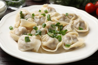 Photo of Delicious pelmeni with green onion on table, closeup