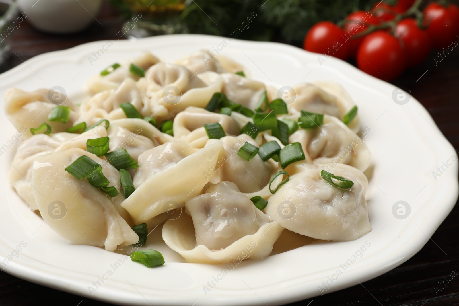 Photo of Delicious pelmeni with green onion on table, closeup