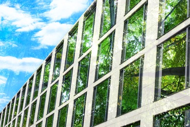 Image of Environment preservation. Double exposure of modern building and trees, low angle view