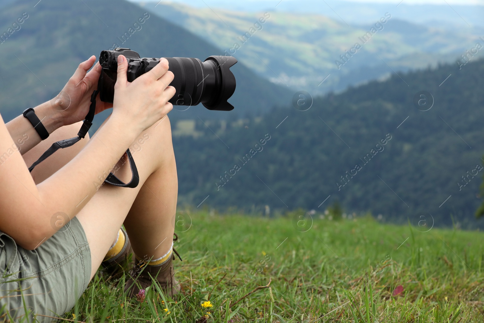 Photo of Young hiker with backpack and camera in mountains, closeup. Space for text