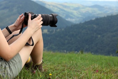 Photo of Young hiker with backpack and camera in mountains, closeup. Space for text