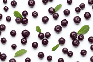 Photo of Ripe acai berries and leaves on white background, flat lay