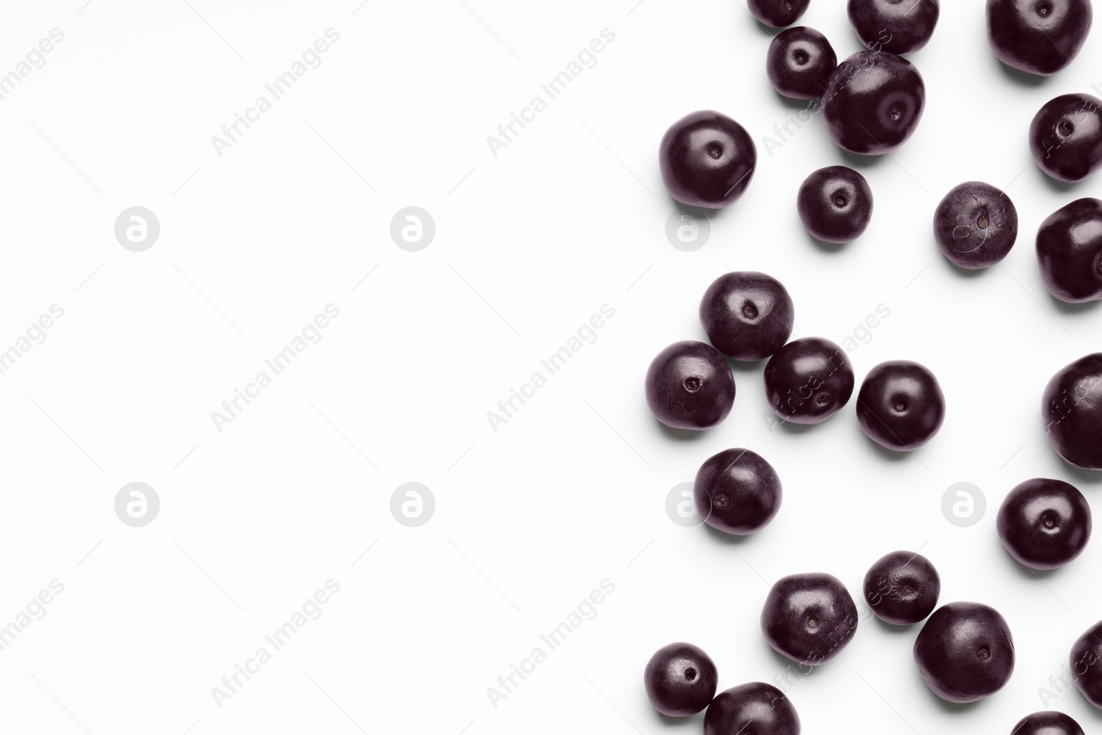 Photo of Ripe acai berries on white background, flat lay. Space for text