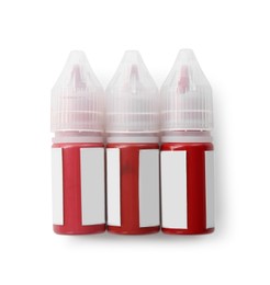 Photo of Bottles of pigments for permanent makeup isolated on white, top view