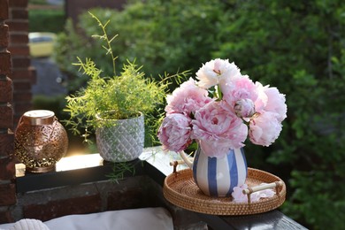 Photo of Beautiful pink peony flowers in vase on balcony railing outdoors