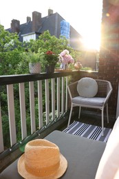 Beautiful hat, different plants and chair at cozy balcony