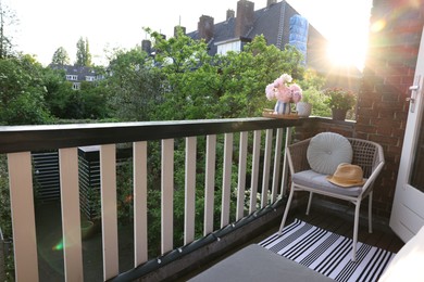 Different plants on railings and chair at cozy balcony outdoors