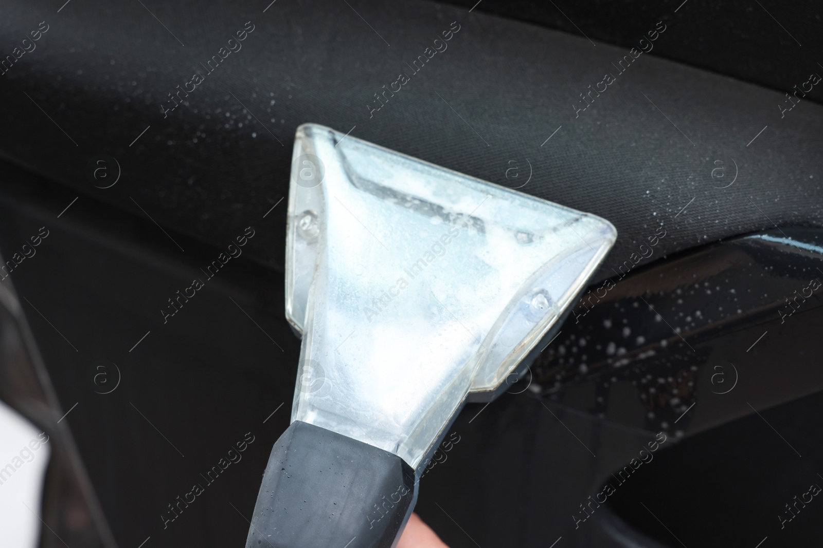 Photo of Cleaning car interior with vacuum cleaner, closeup