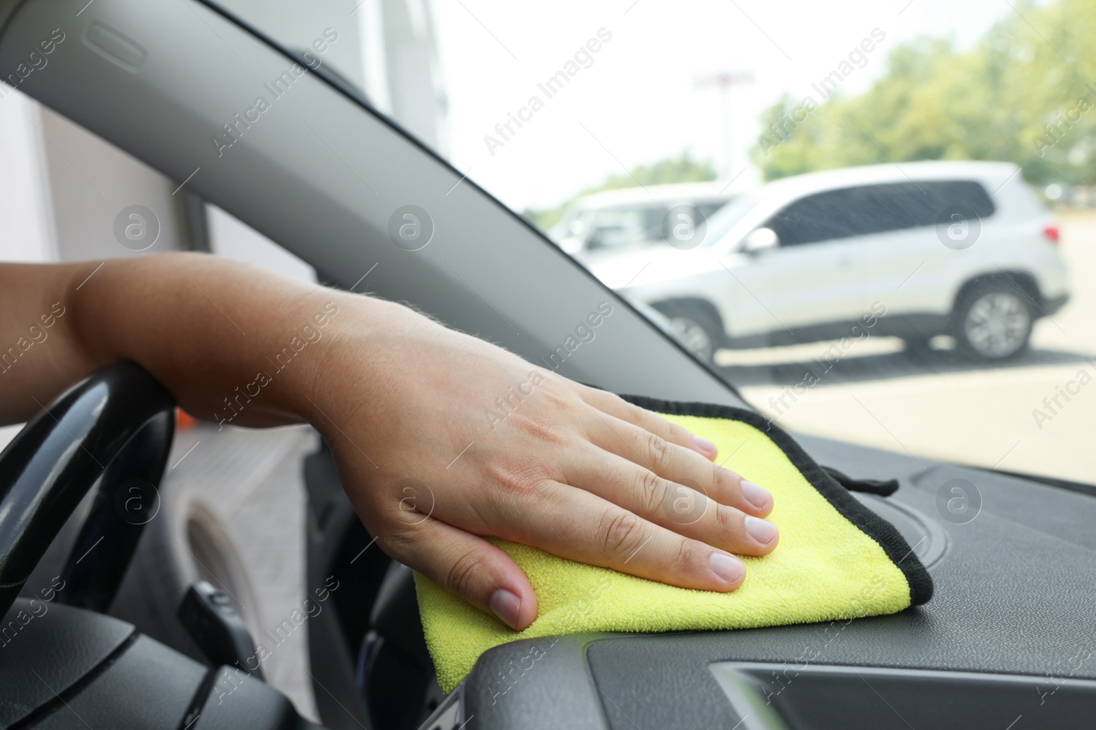 Photo of Man cleaning car interior with rag, closeup