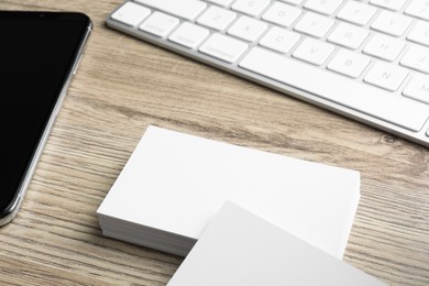 Photo of Blank business cards and keyboard on wooden table. Mockup for design