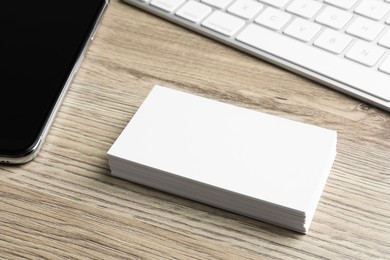 Photo of Blank business cards and keyboard on wooden table. Mockup for design