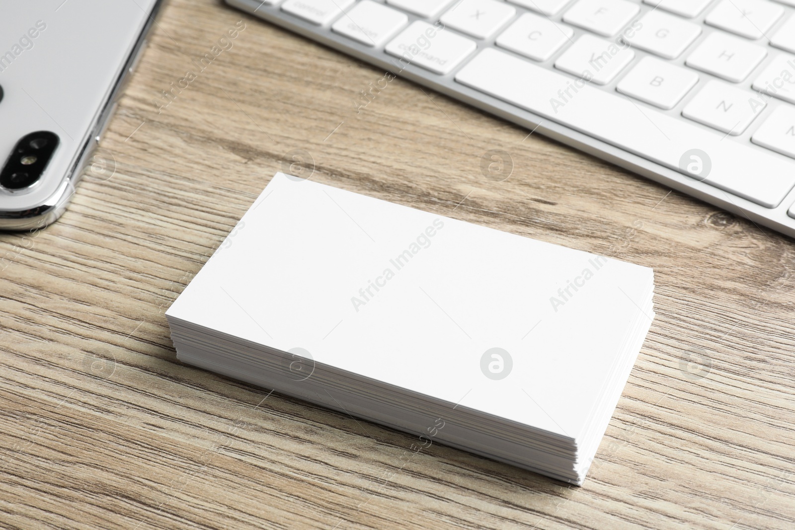 Photo of Blank business cards and keyboard on wooden table. Mockup for design