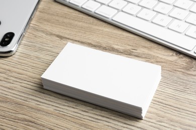 Photo of Blank business cards and keyboard on wooden table. Mockup for design