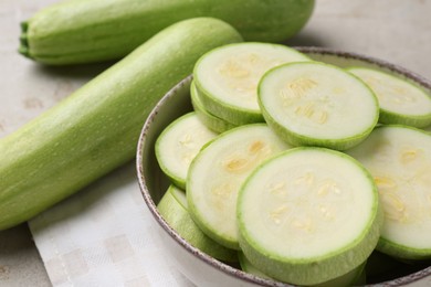 Photo of Fresh cut and whole zucchinis on table, closeup