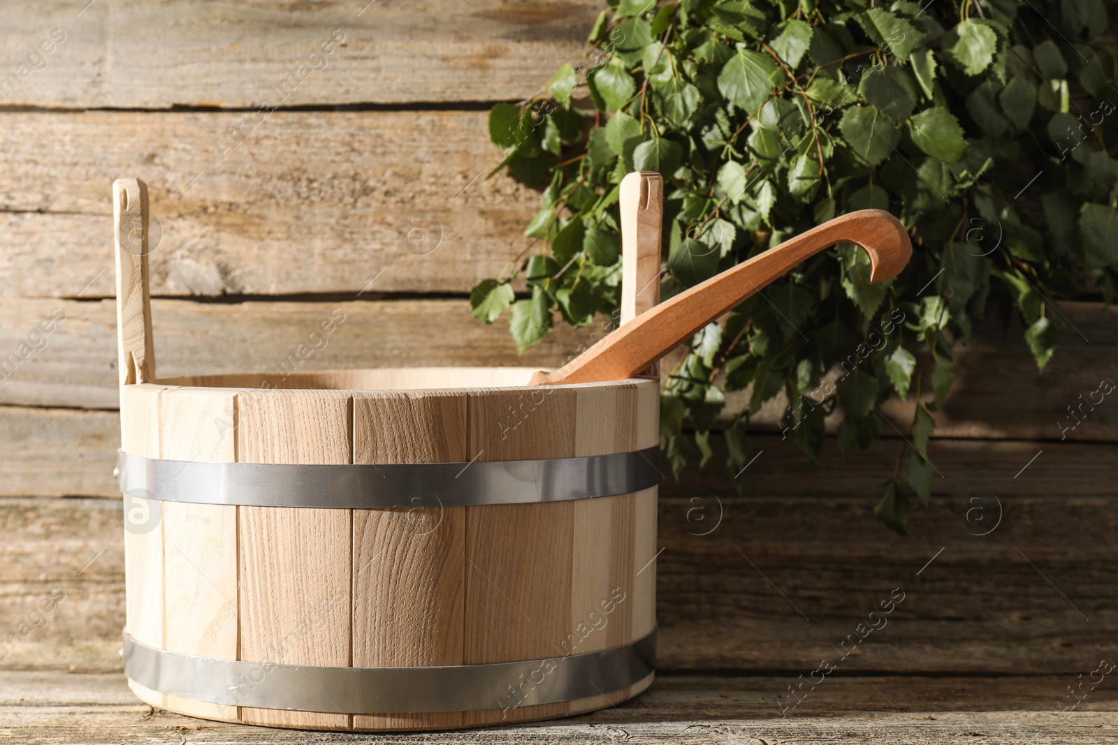 Photo of Sauna equipment. Bucket and ladle on wooden surface